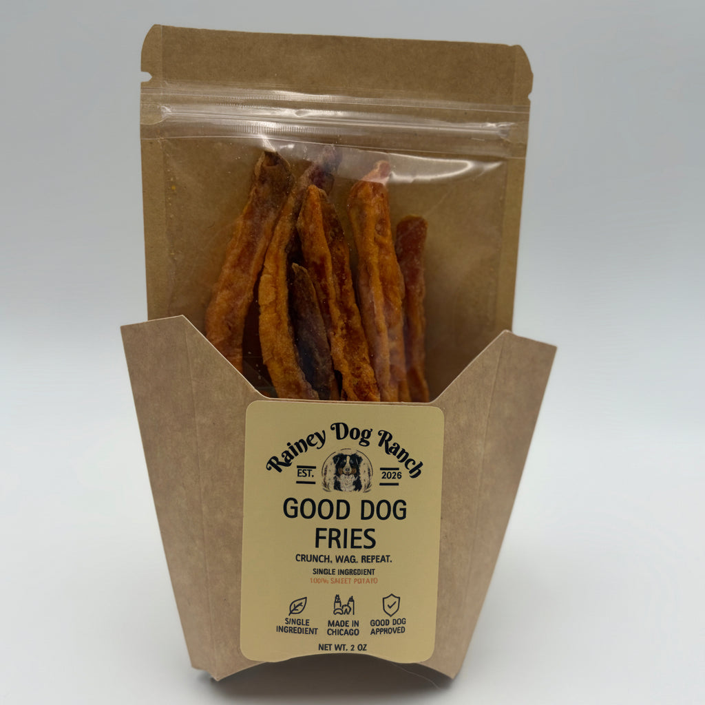 A bag of Raincy Dog Ranch Good Dog Fries, featuring brown paper packaging with a clear window showing the golden-brown dog treats inside, set against a neutral light gray background.